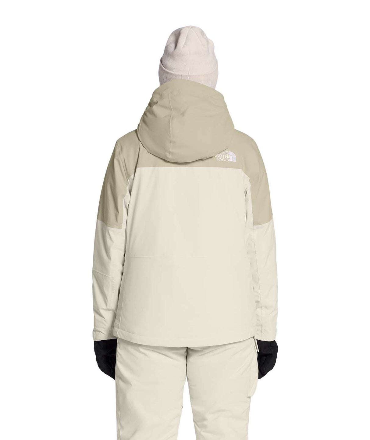 WFreedomInsulatedJacket-Person wearing a light-colored snowsuit with a hood on a white background