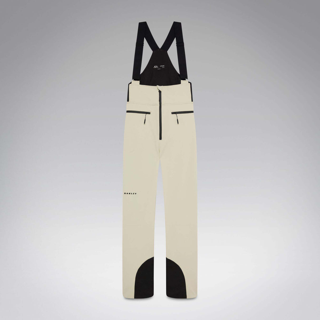 WIcicleSoftshellBib-A pair of ski bib pants in off-white with black suspenders, black zipper details, and black paneling at the lower legs, shown against a neutral gray gradient background.