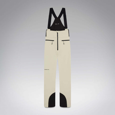 WIcicleSoftshellBib-A pair of ski bib pants in off-white with black suspenders, black zipper details, and black paneling at the lower legs, shown against a neutral gray gradient background.