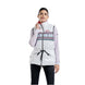 WMayenQuiltedPolyfillVest- A woman modeling a white sleeveless zip-front puffer vest with a colorful geometric pattern across the chest, black drawstring waist, and a red inner collar, worn over a light purple long-sleeve top and black pants against a white background.