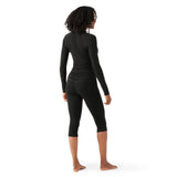 WMerinoBaselayer3_4Pant-Person wearing black long-sleeve top and capri leggings on a white background