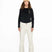 WMula2LInsulatedPant-Woman wearing a black top and white pants with a beige beanie on a white background