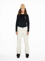 WMula2LInsulatedPant-Woman wearing a black top and white pants with a beige beanie on a white background