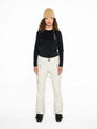 WMula2LInsulatedPant-Woman wearing a black top and white pants with a beige beanie on a white background