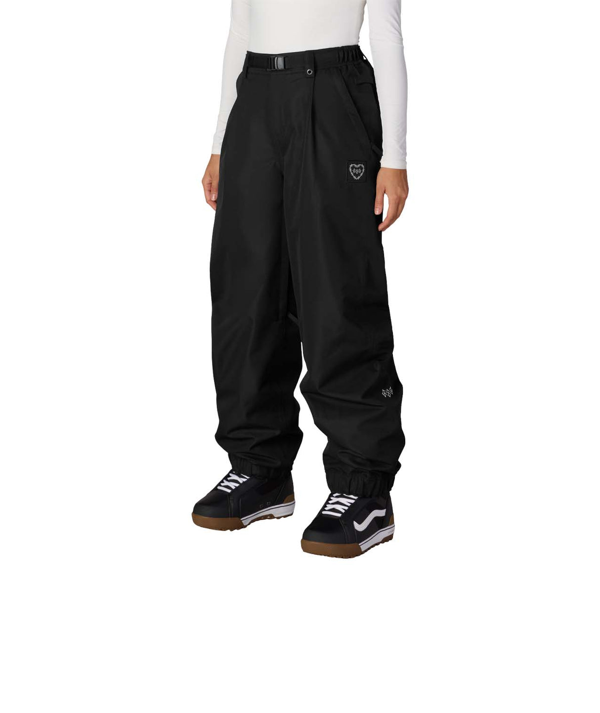 WOutlineShellPant-Person wearing black snow pants with a white heart stitched under the left front pocket on a white background