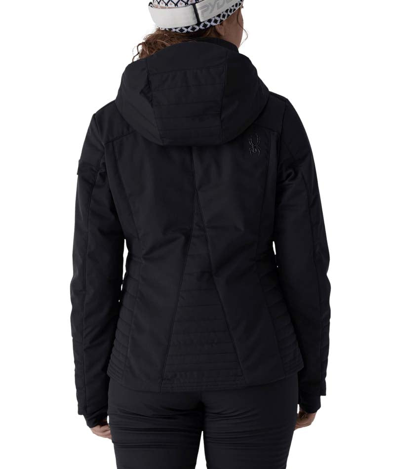 WSchatziJacket- Woman wearing a black ski jacket on a white background