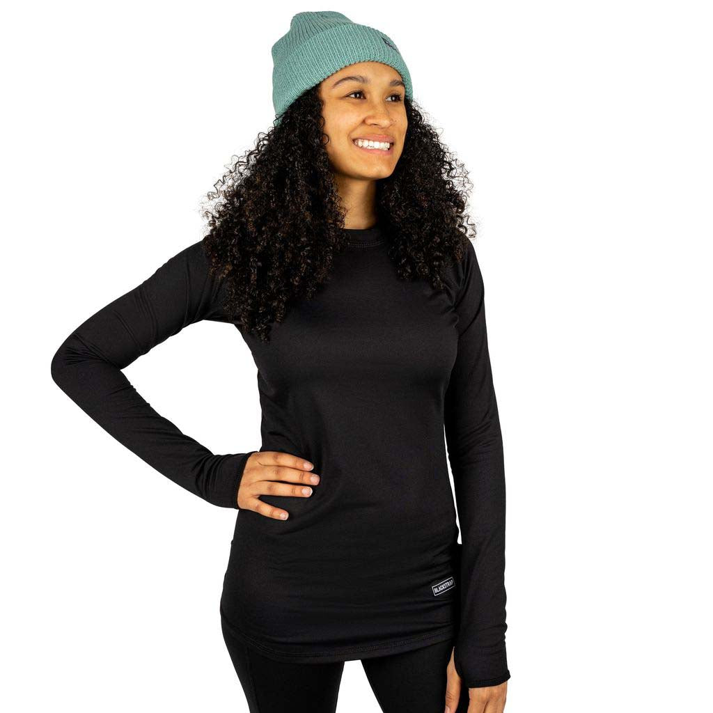 WSkylinerCrewneck-Woman wearing a black long-sleeve shirt and green beanie on a white background