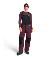 WSummitVerbierGTXBib-Person wearing a maroon snowsuit with black accents on a white background