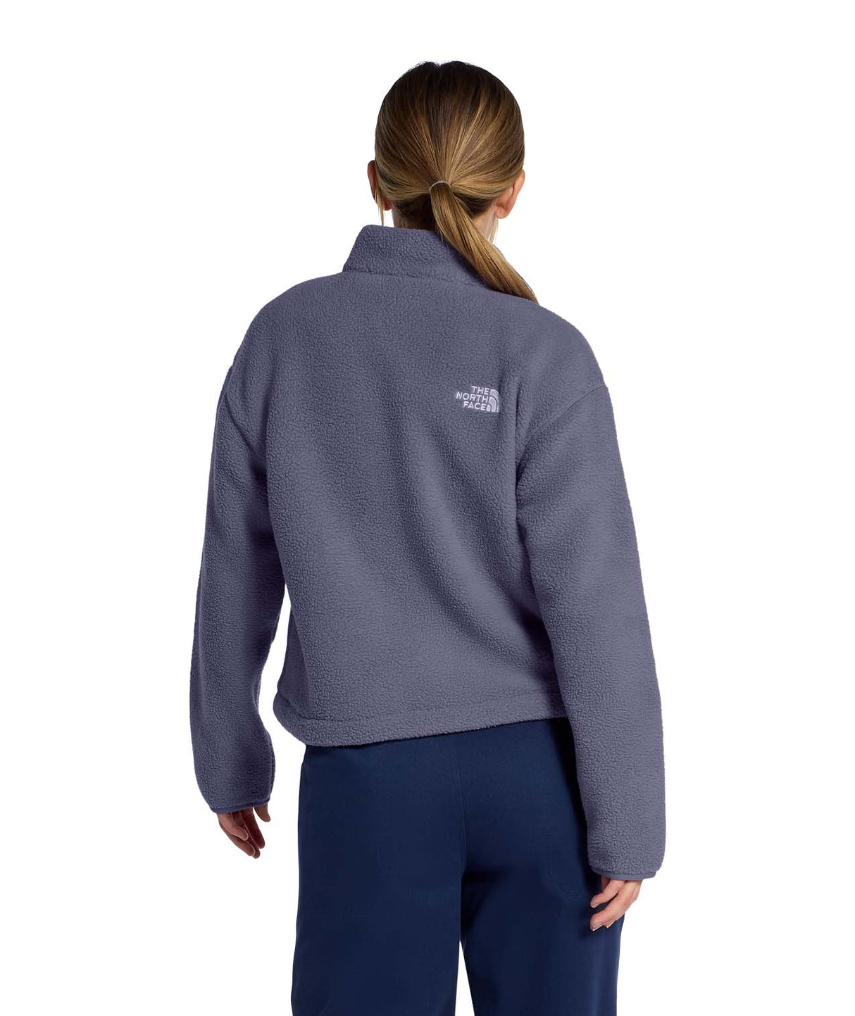 WTNFFleeskiFullZipJacket- Person wearing a purple fleece jacket with The North Face logo on a white background