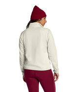 WTNFPerformanceFleece1_4Zip- Person wearing a beige and brown color-blocked jacket with a red beanie on a white background