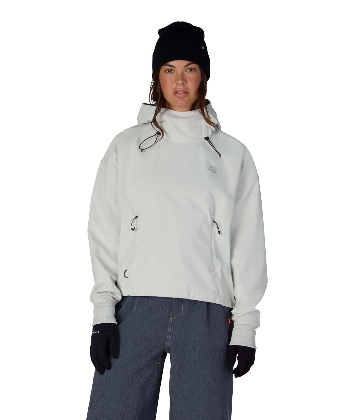 WWaterproofTeamCropHoody-Person wearing a light gray jacket, black beanie, and dark pants on a white background