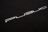 WarpCrewneck-A close-up of a black textured surface featuring the word 'PUBLIC' in a stylized white sans-serif font.