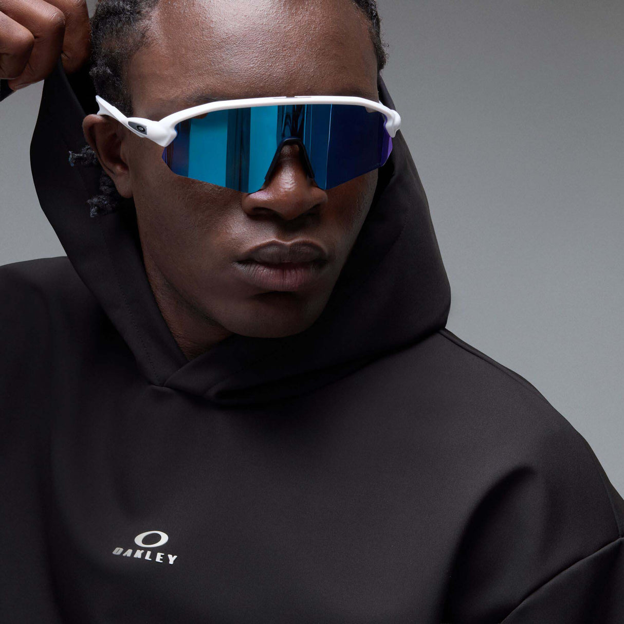 WintertideScratchedHoodie-A black pullover hoodie with a small white Oakley logo on the left chest, displayed against a neutral gray gradient background.