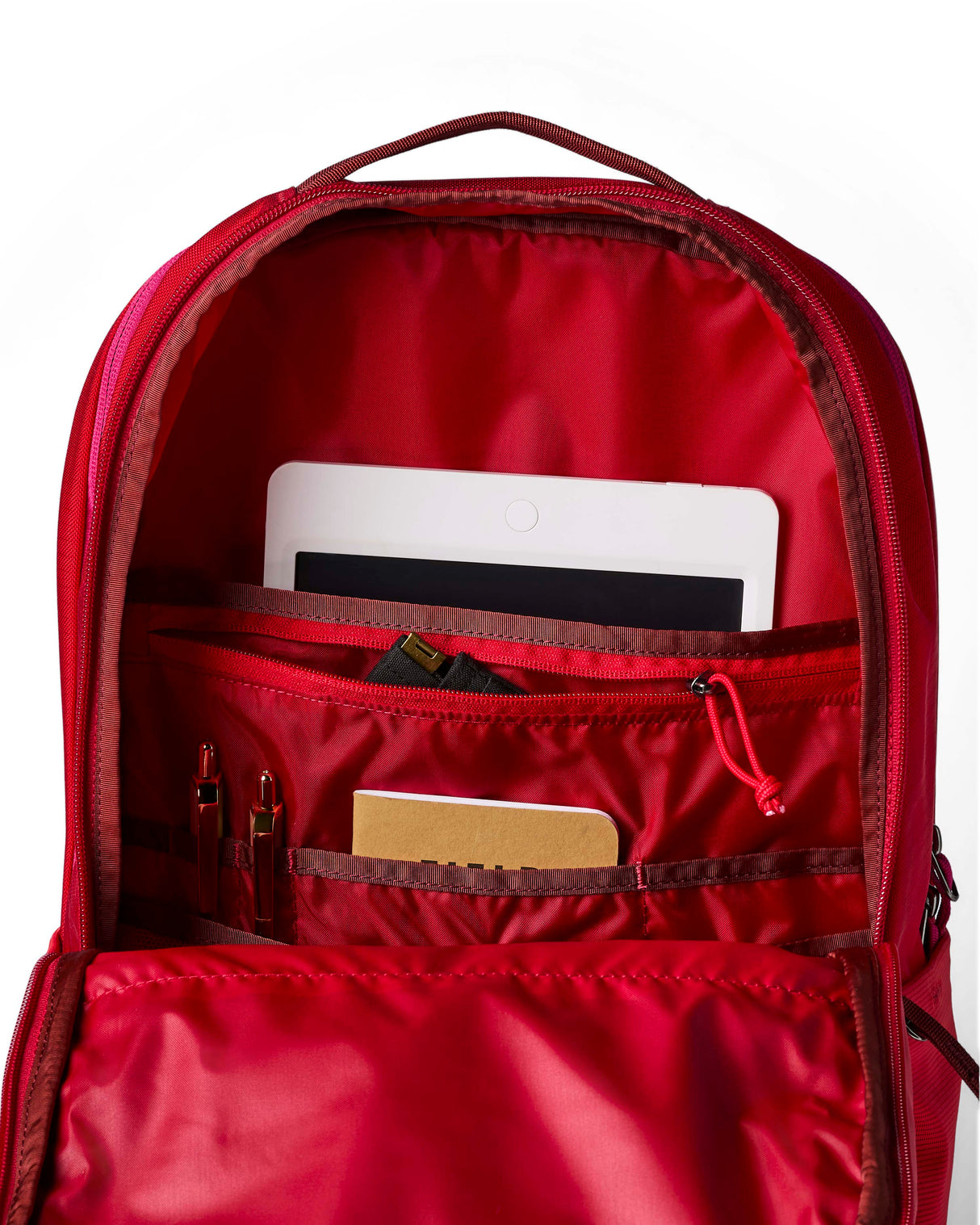 allpa-26l-daypack-A red Cotopaxi backpack with a matte finish, featuring a top zippered compartment, a main compartment, and a front zippered pocket. The brand logo is printed in orange on the front center.