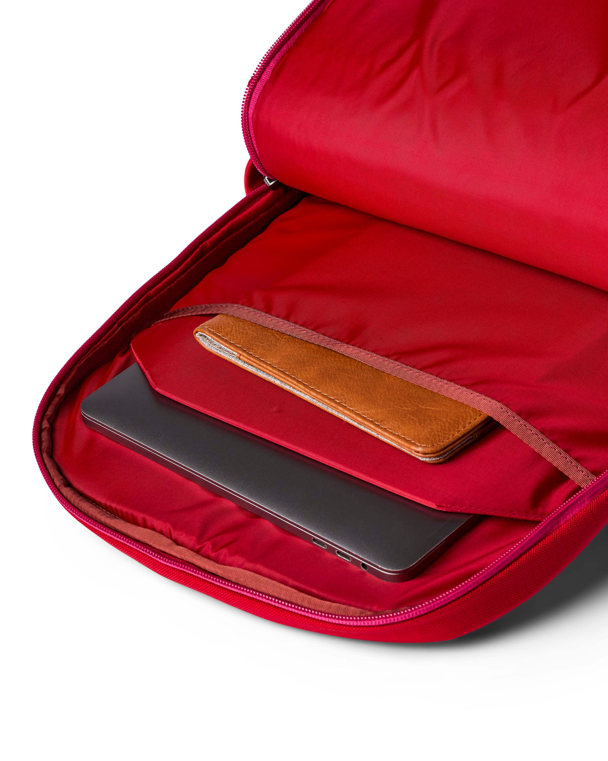 allpa-26l-daypack-A red Cotopaxi backpack with a matte finish, featuring a top zippered compartment, a main compartment, and a front zippered pocket. The brand logo is printed in orange on the front center.