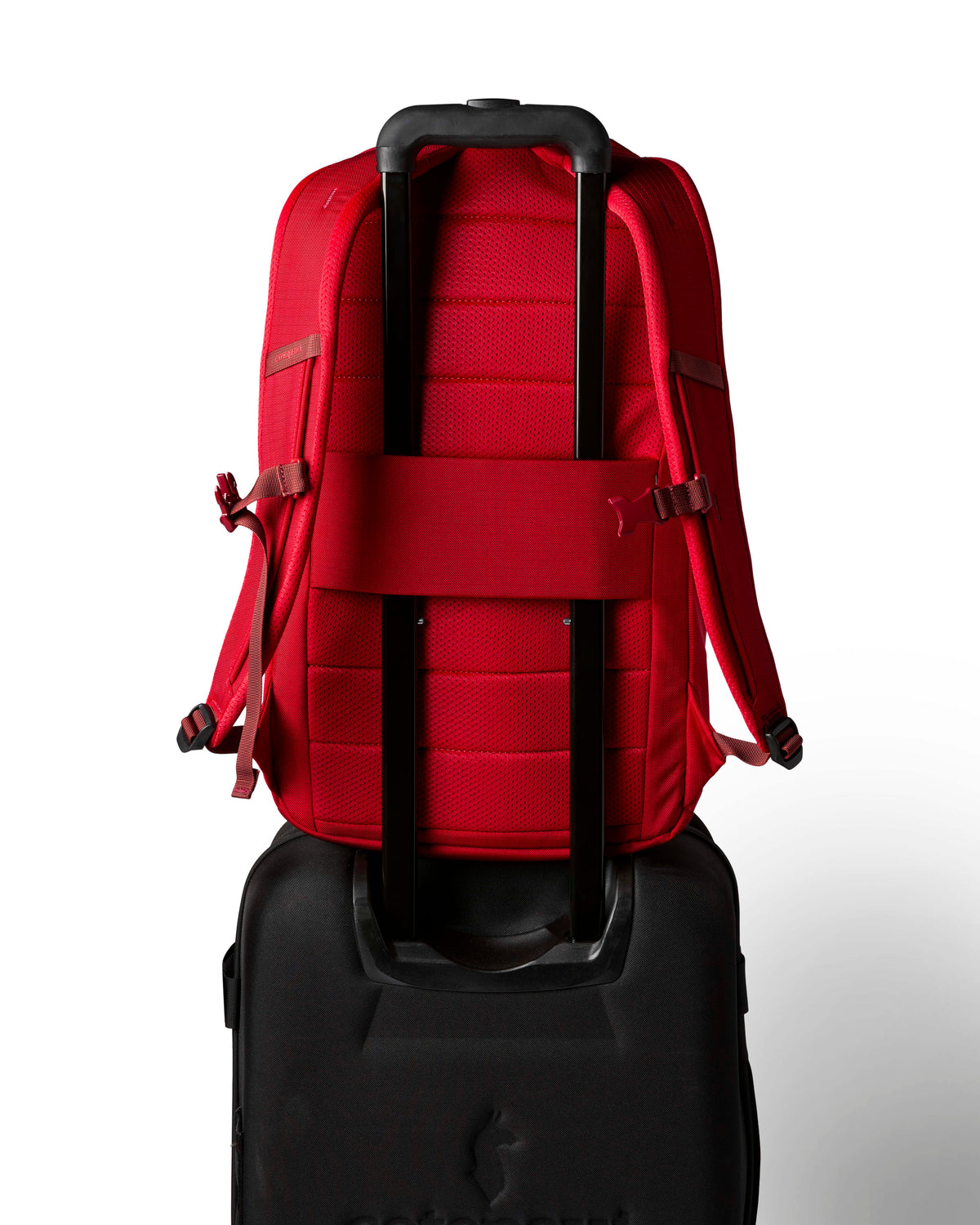 allpa-26l-daypack-A red Cotopaxi backpack with a matte finish, featuring a top zippered compartment, a main compartment, and a front zippered pocket. The brand logo is printed in orange on the front center.