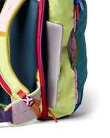 allpa-42l-travel-pack-A Cotopaxi backpack in teal blue with pink and purple accents, featuring a light blue cat logo and the brand name on the front, set against a plain white background.