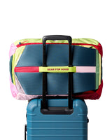 allpa-42l-travel-pack-A Cotopaxi backpack in teal blue with pink and purple accents, featuring a light blue cat logo and the brand name on the front, set against a plain white background.