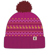 cumbre-2.0-beanie-A knit pom-pom beanie hat in magenta pink with a multicolor pattern featuring yellow and light pink motifs, a dark red pom-pom, and a ribbed cuff with a small black logo patch.