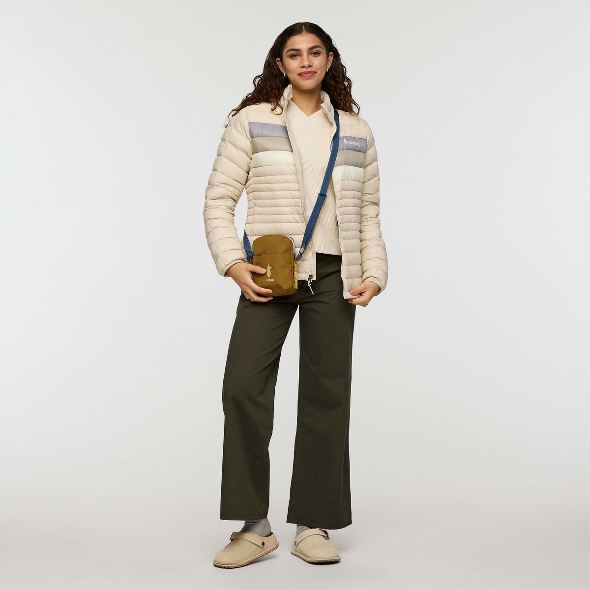 w-fuego-down-jacket- A beige quilted puffer jacket with a gray chest stripe and a visible Cotopaxi logo on the left chest, displayed against a clean white background.