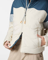 w-lumbre-insulated-jacket- A color-blocked puffer jacket, featuring an off-white body, a navy blue yoke, light gray sleeves, and a bright orange interior lining, displayed on a clean white background.